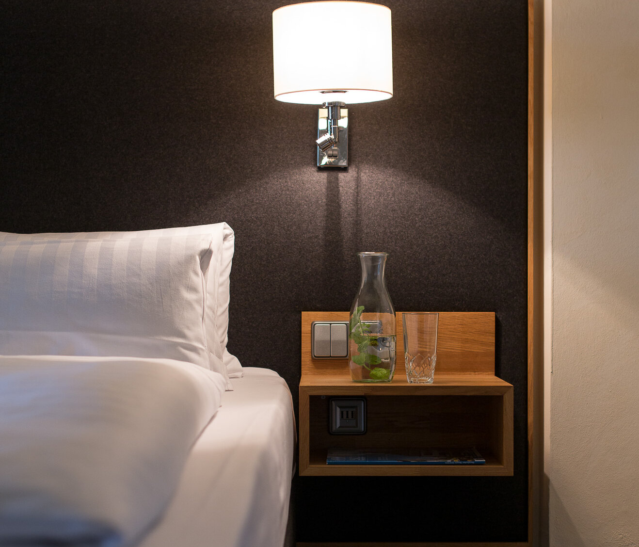 Nachttisch mit Lampe im Hotelzimmer Detailansicht eines Nachttischs mit Lampe und Bett im Hotelzimmer des Hotel-Landgasthof KREUZ