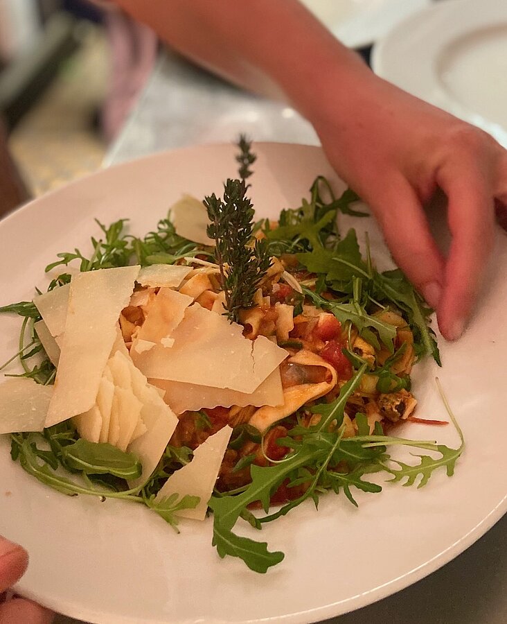 Serviertes Hauptgericht mit Gemüse Kellner serviert Gericht mit Gemüse und Fleisch auf weißem Teller