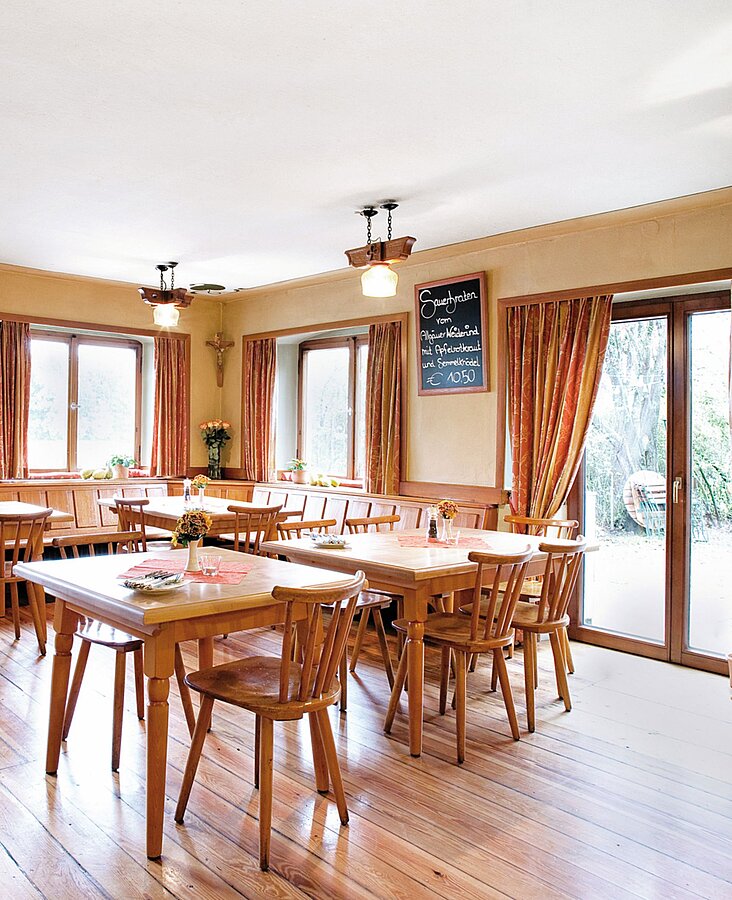 Traditioneller Gastraum mit Holzeinrichtung Gemütlicher Gastraum mit Holzmöbeln und eingedeckten Tischen