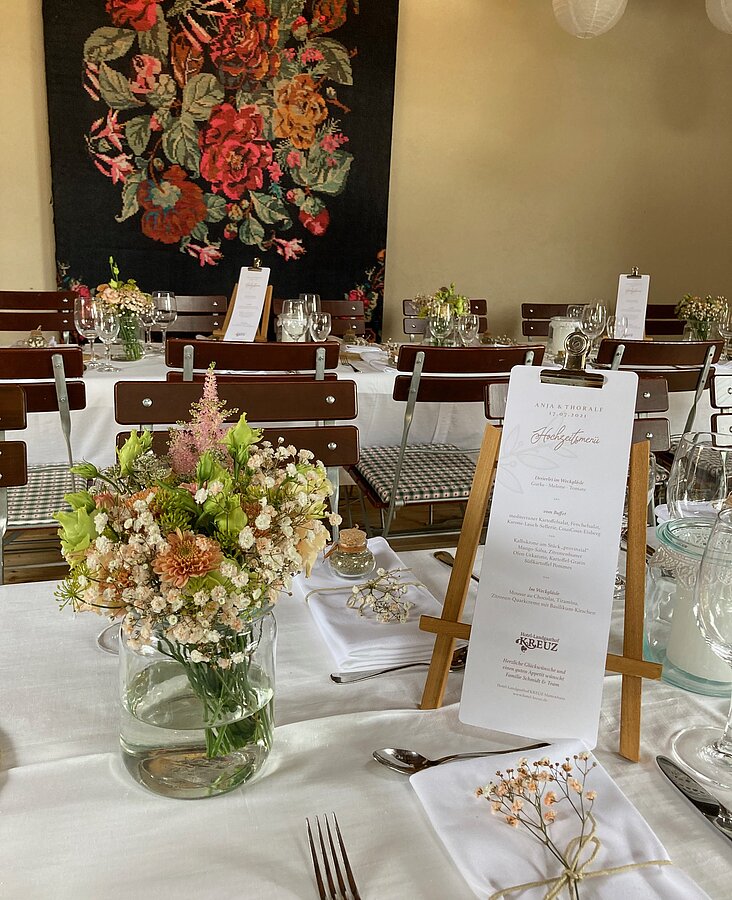 Eleganter Gastraum mit Blumendekoration Heller Gastraum mit eingedeckten Tischen und Blumenschmuck