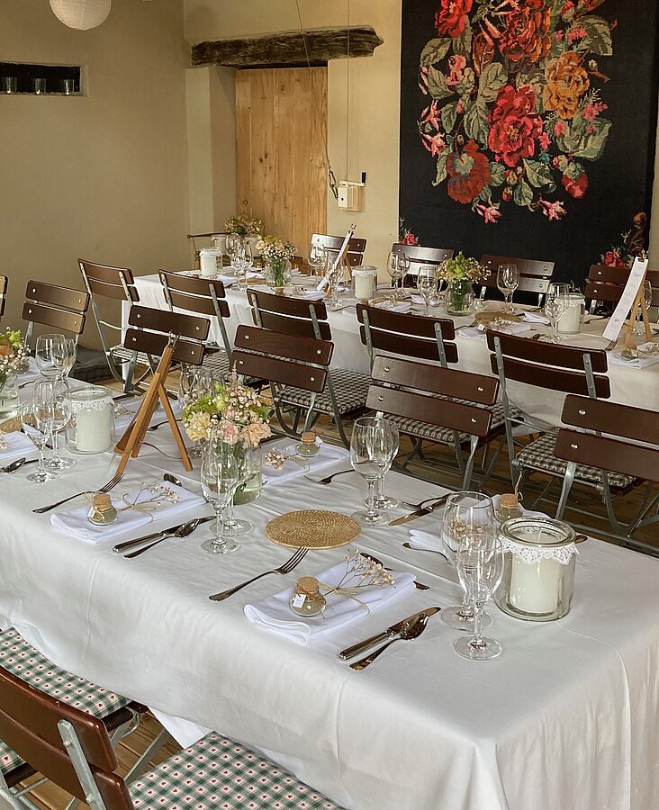 Rustikaler Gastraum mit festlicher Tafel Festlich gedeckter Tisch im rustikalen Gastraum mit Holzwand