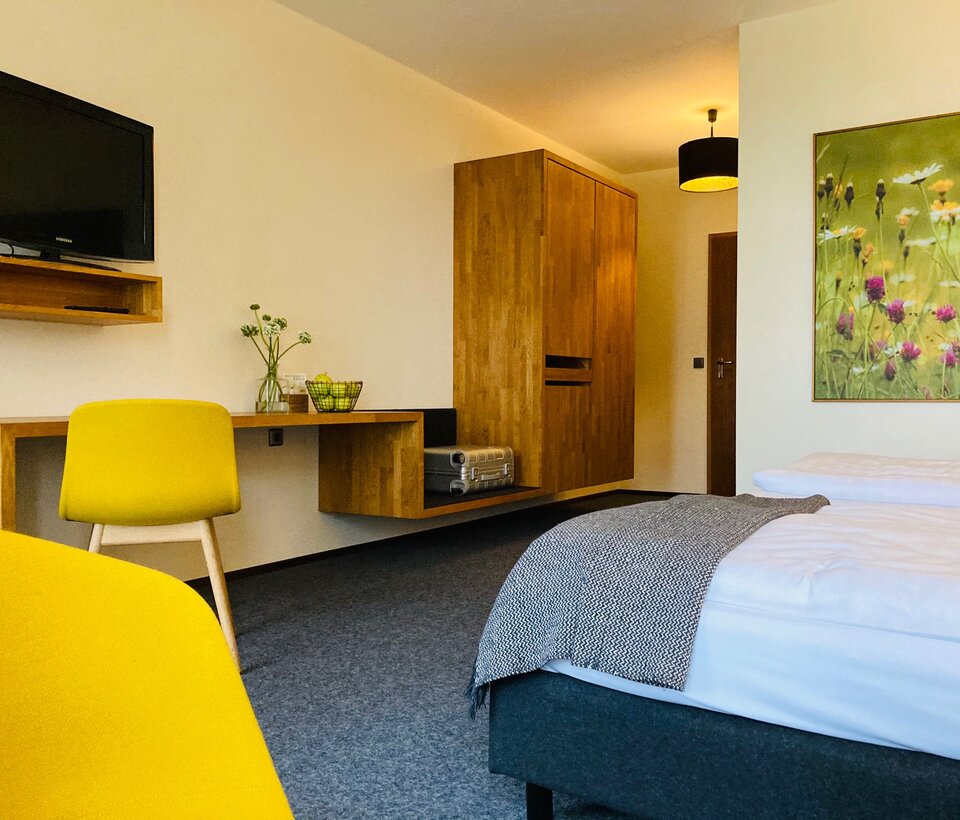 Doppelzimmer mit Naturblick Gemütliches Doppelzimmer mit Holzmöbeln und Fenster zur grünen Umgebung im Hotel-Landgasthof KREUZ