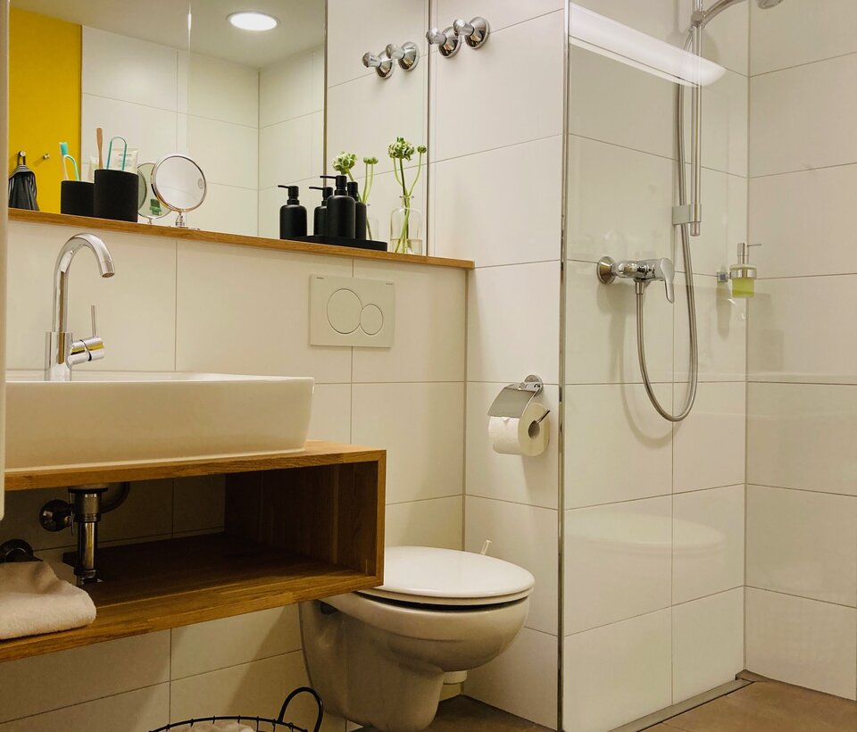 Badezimmer mit Dusche im Hotel-Landgasthof KREUZ Modern ausgestattetes Bad mit Dusche, Waschbecken und Spiegel im Hotel-Landgasthof KREUZ