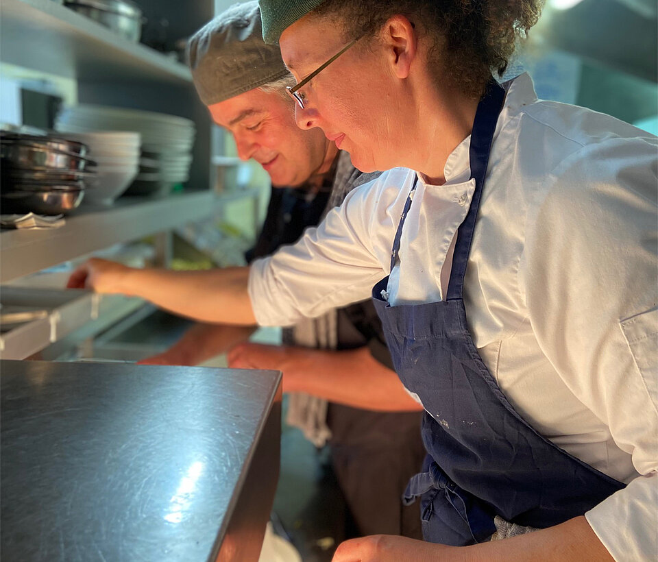 Köchin bei der Zubereitung Köchin richtet Speisen in der Küche an